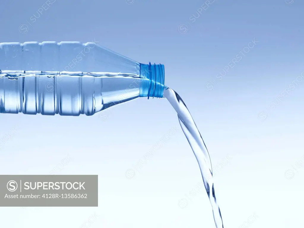 Pouring water from a plastic bottle, studio shot.