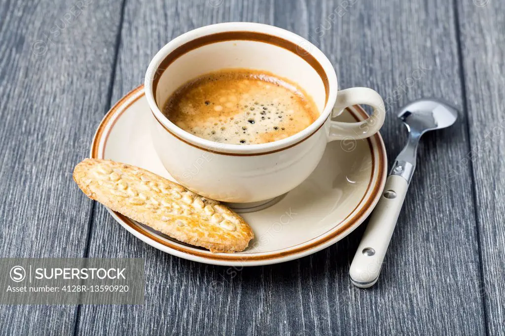 Espresso in coffee cup with biscuit.
