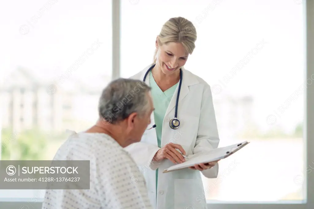 Female doctor and senior man in hospital.