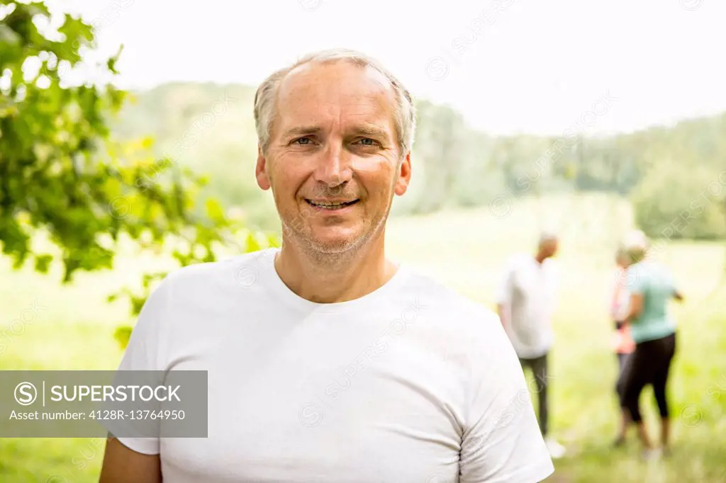 MODEL RELEASED. Mature man wearing white t-shirt smiling towards camera.
