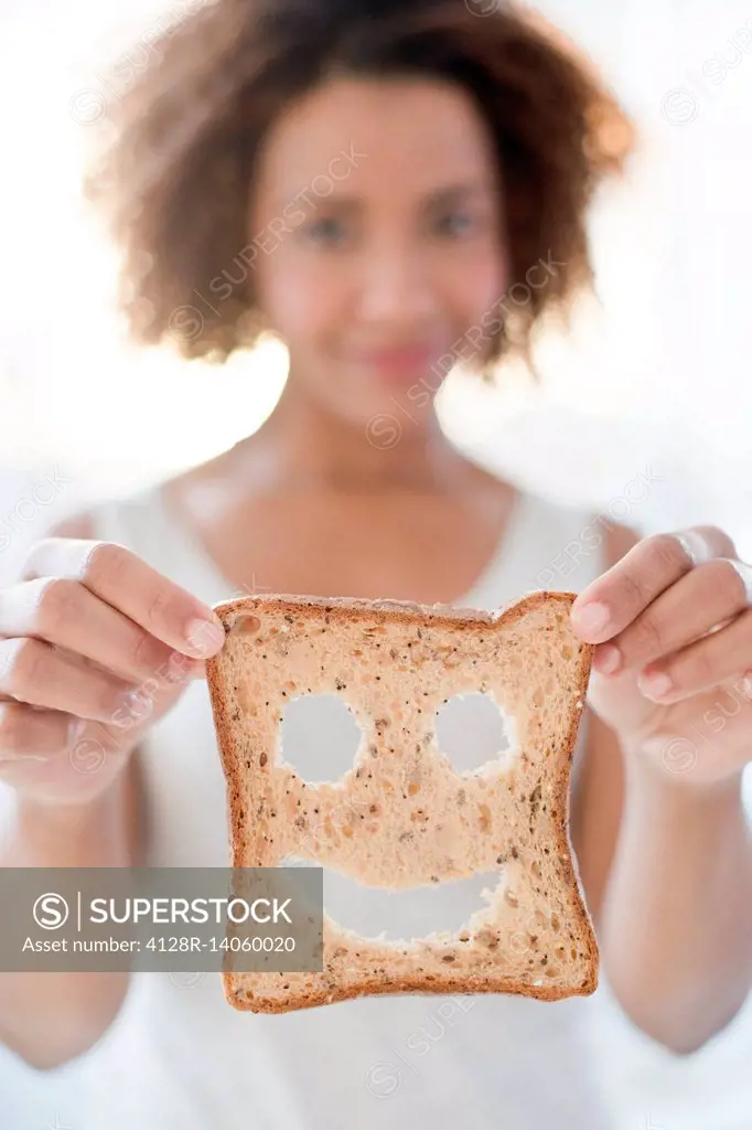 Woman holding bread with smiley face