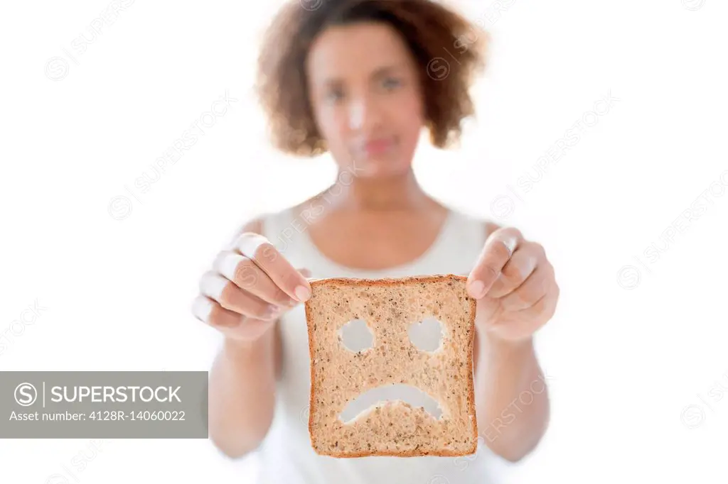 Woman holding bread with sad face