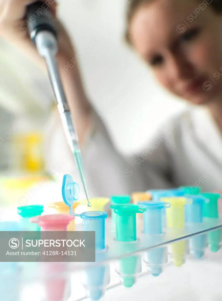 Biological research. Scientist pipetting a liquid into Eppendorf tubes.