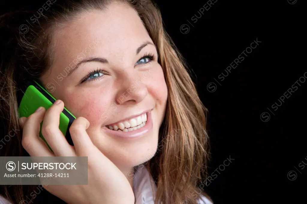 Mobile phone use. Teenage girl talking on a mobile phone.