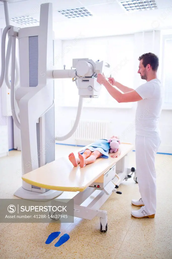 Doctor preparing girl for x-ray in hospital