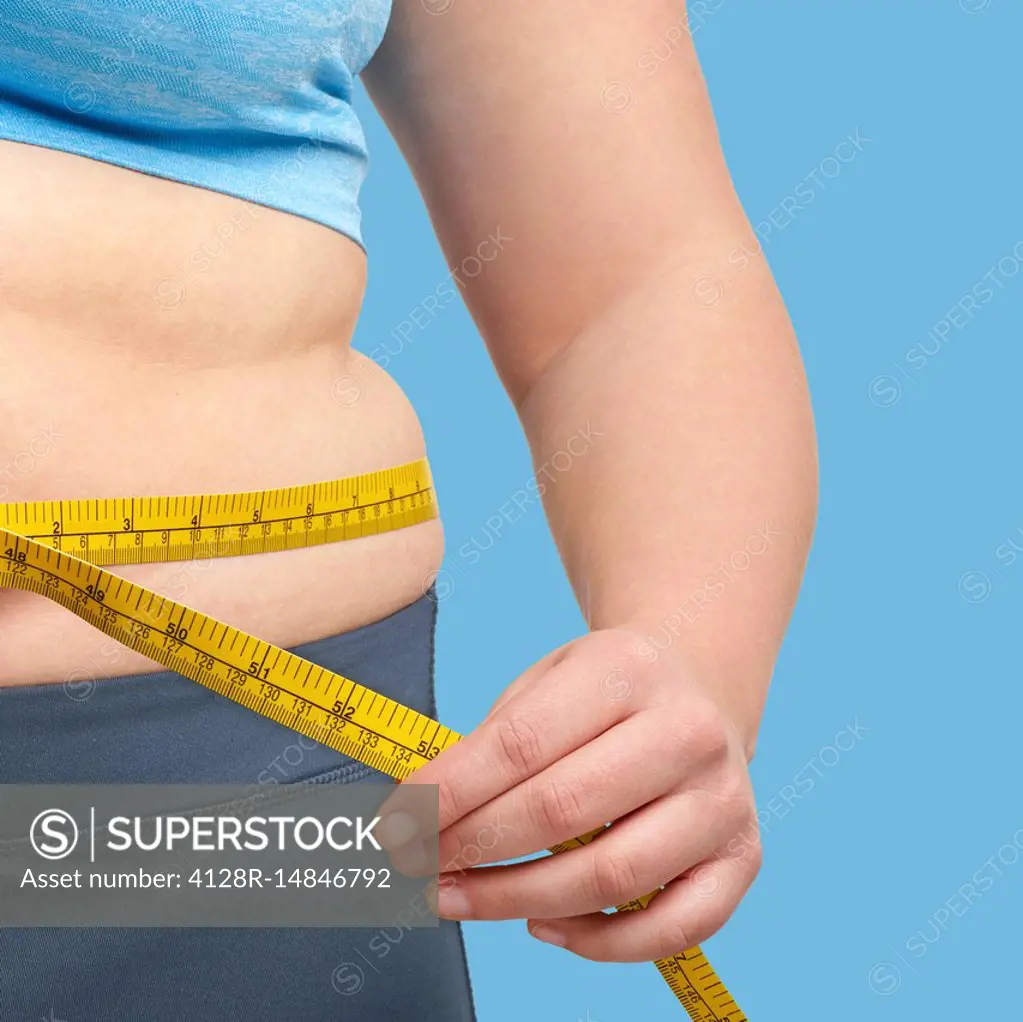 Overweight woman measuring waist