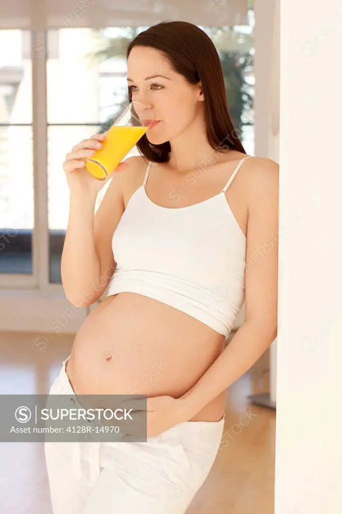 Pregnant woman drinking orange juice.