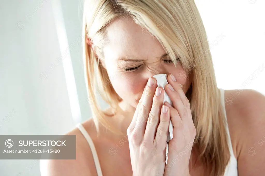 Woman blowing her nose.