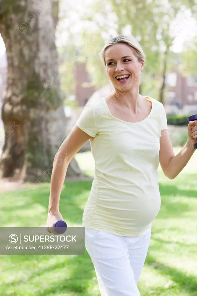 MODEL RELEASED. Pregnant woman exercising. She is 8 months pregnant.