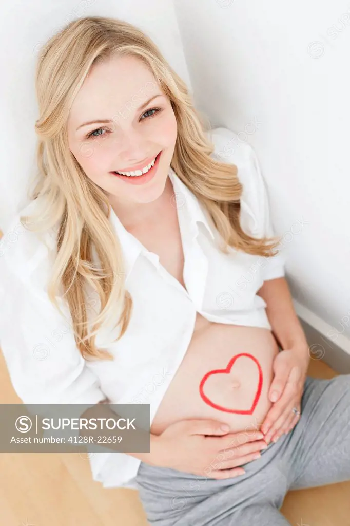 MODEL RELEASED. Happy pregnant woman. She is seven months pregnant.