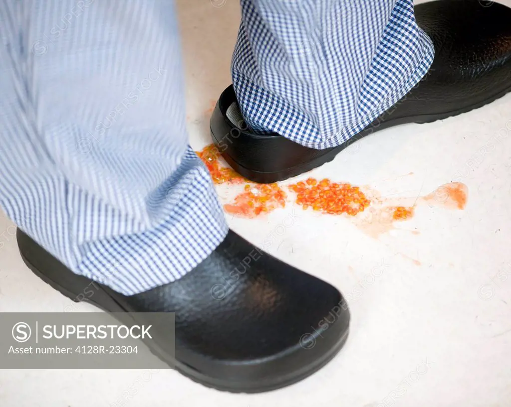 MODEL RELEASED. Slip hazard. Tomato seeds on a kitchen floor.