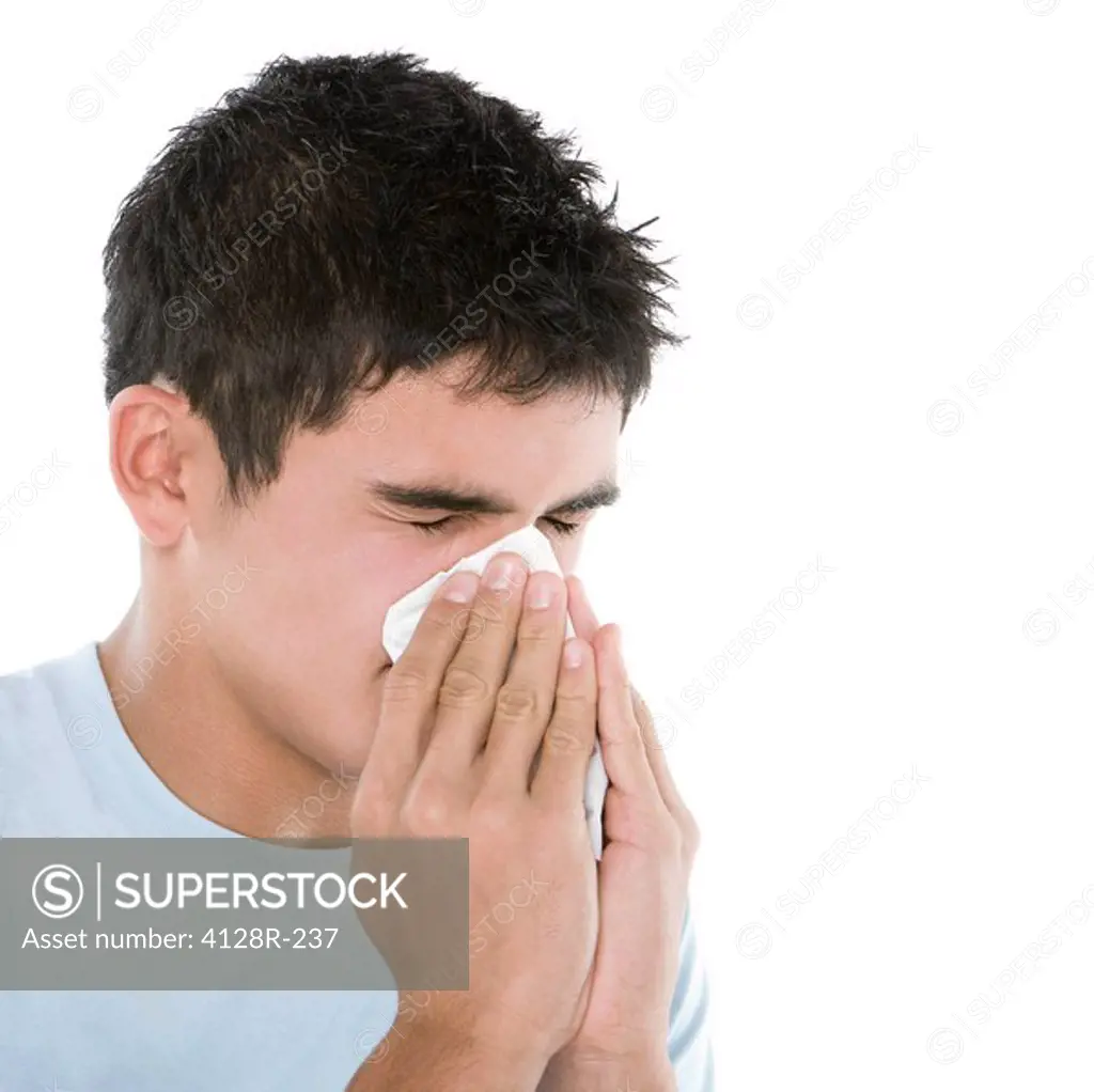Teenage boy sneezing.