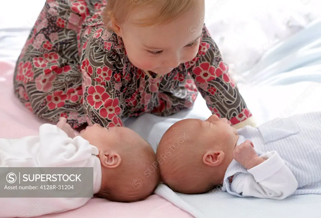 MODEL RELEASED. One year old girl with her two week old fraternal twin siblings.