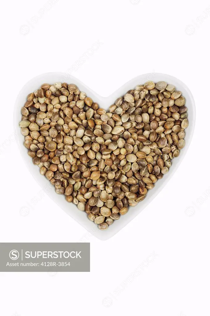 Hemp seeds Cannabis sativa in heart_shaped dish.
