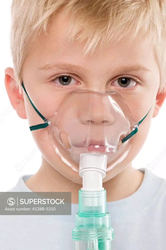 Asthma treatment. Boy using a nebulizer to treat asthma.