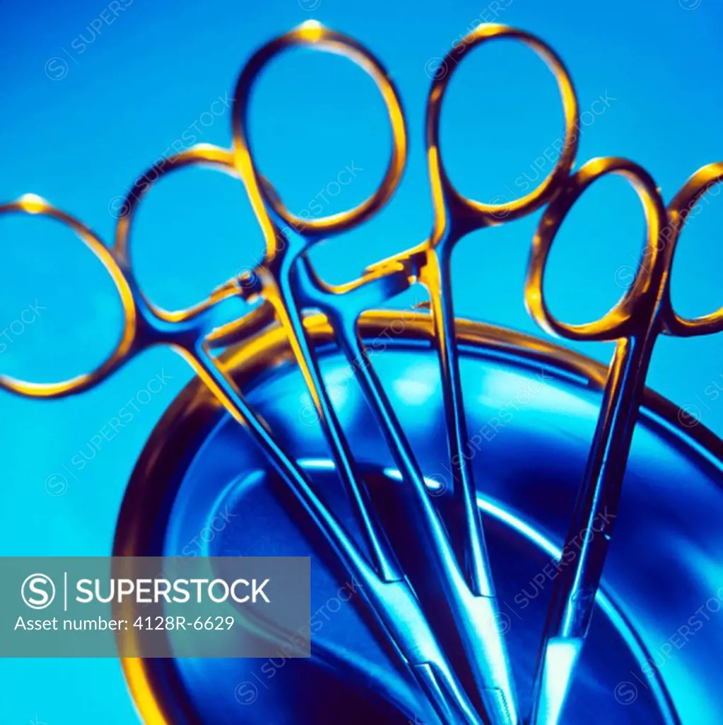 Surgical forceps and scissors in a metal bowl