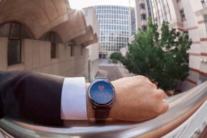 Businessman taking his pulse on a smartwatch