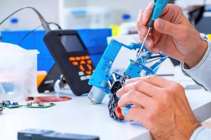 Person working with robotic parts.
