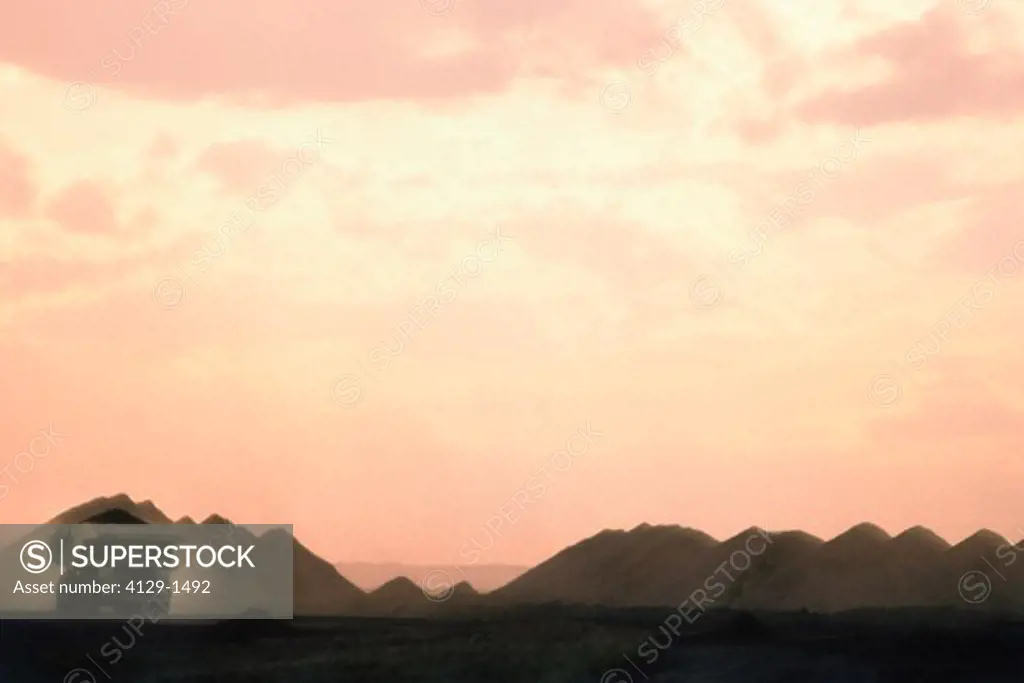 Dump truck in coal mine at sunset