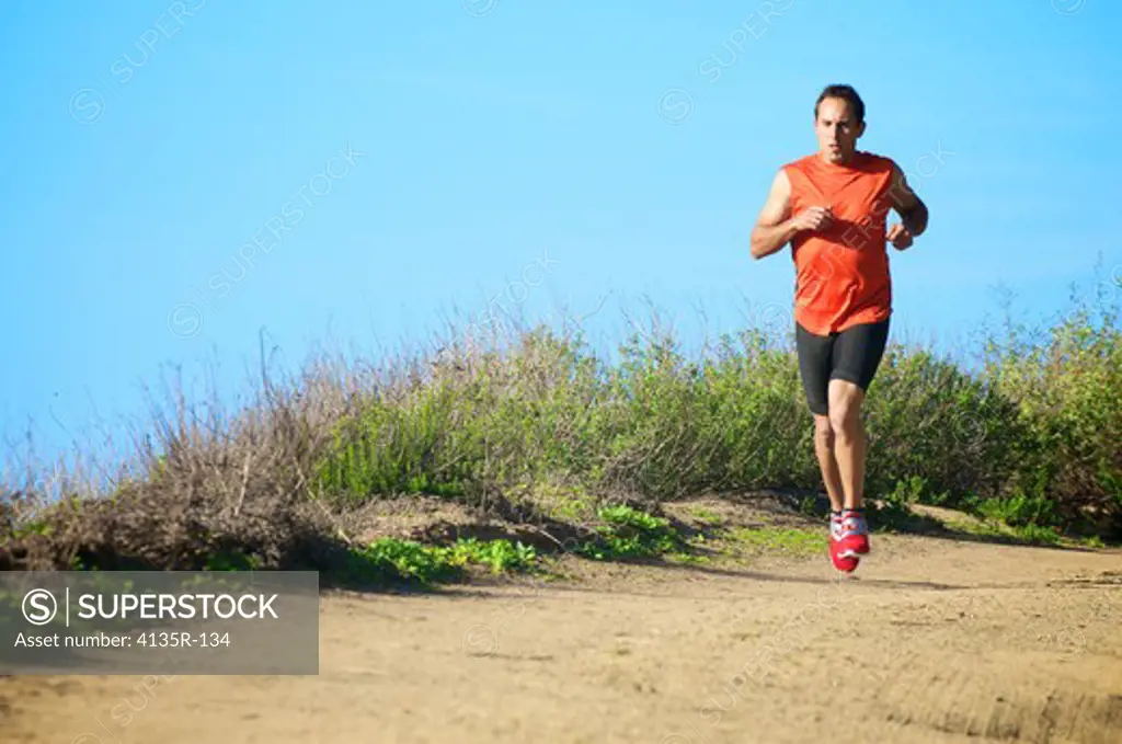 Male triathlete running on trail, San Elijo, Solana Beach, California, USA