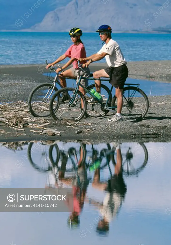 mountain bikers along kluane lake kluane national park reserve, world heritage site, yukon territory, canada.