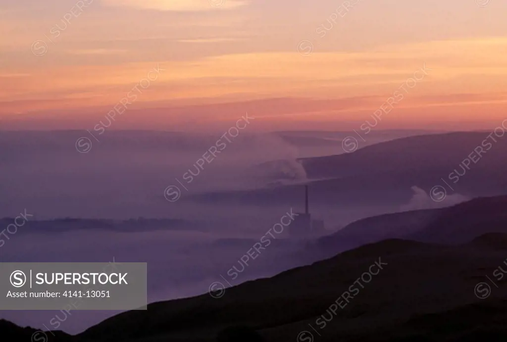 dawn at hope valley with cement factory in distance. fog in valley caused by weather inversion. peak district, derbyshire, uk.