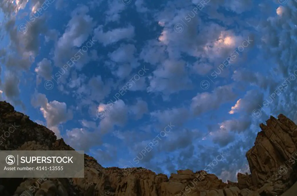 cumulus clouds over granite cliffs at cabo san lucas, baja california, mexico 