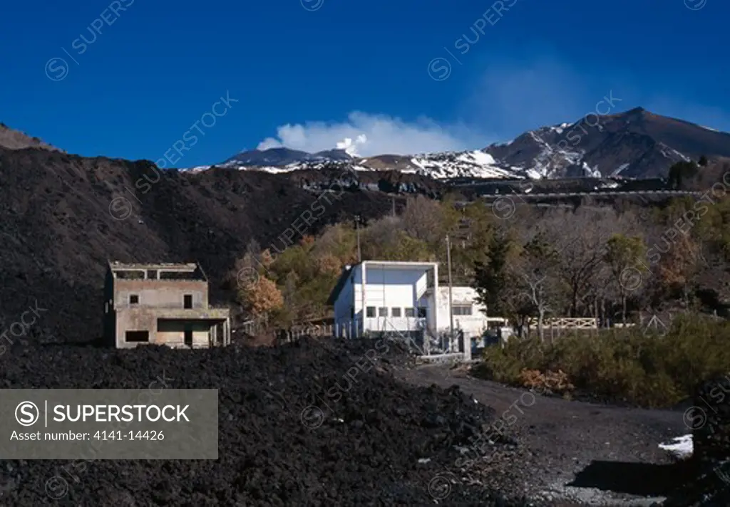 building destroyed by lava flow with new house built close by (bordering old lava flow) etna regional park, sicily, italy