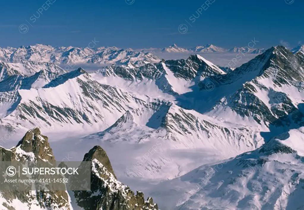 val d'aosta - mont blanc range dent de jetoula (3342 m), ferret valley under the clouds. the peaks above coumayeur are grande rochere >>