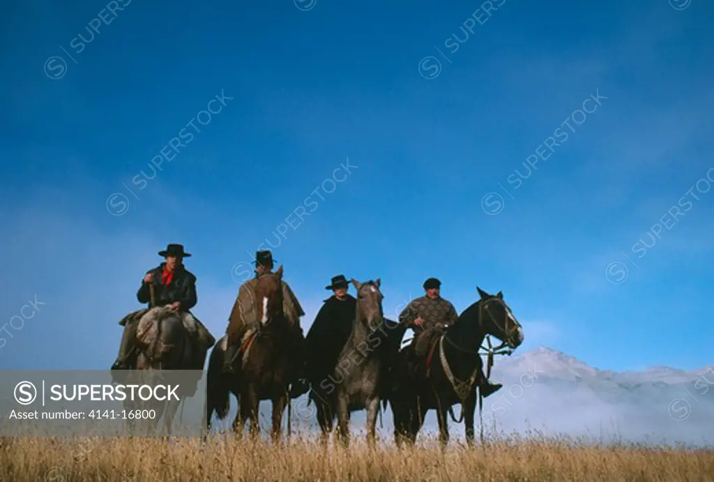 four mounted gauchos near trevelin, patagonia, southern argentina, south america