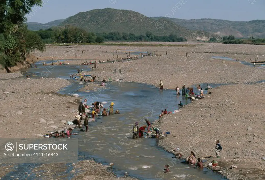people bathing & washing in river k'ore, ethiopia