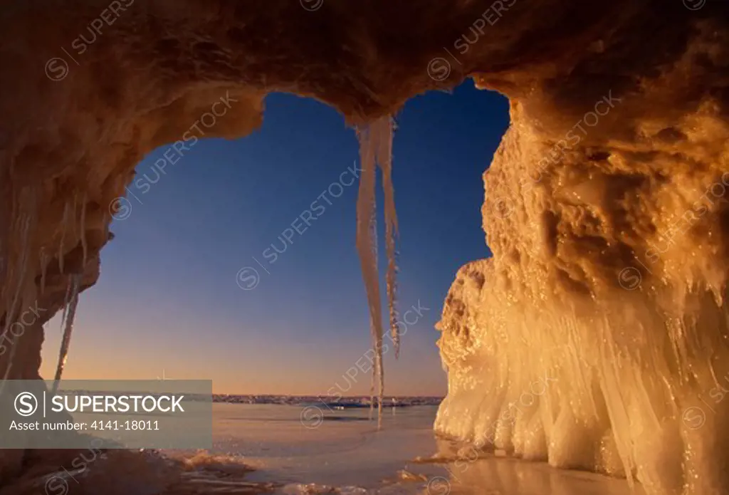 ice cave winter view from inside, with icicles at entrance near whitefish point, lake superior, chippewa county, michigan, northern usa