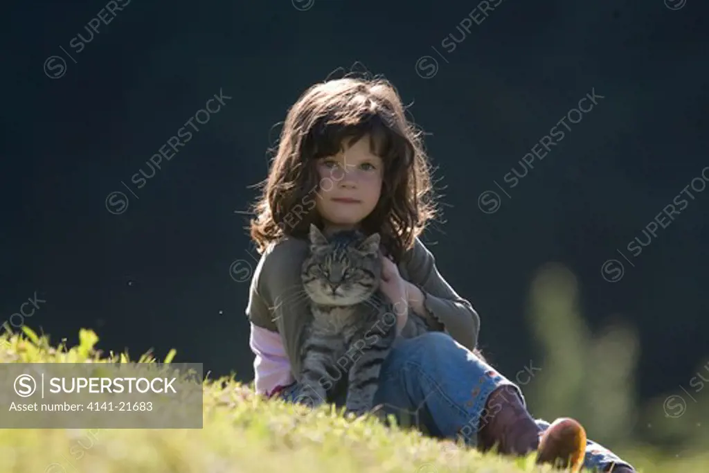 young girl stroking domestic cat. 