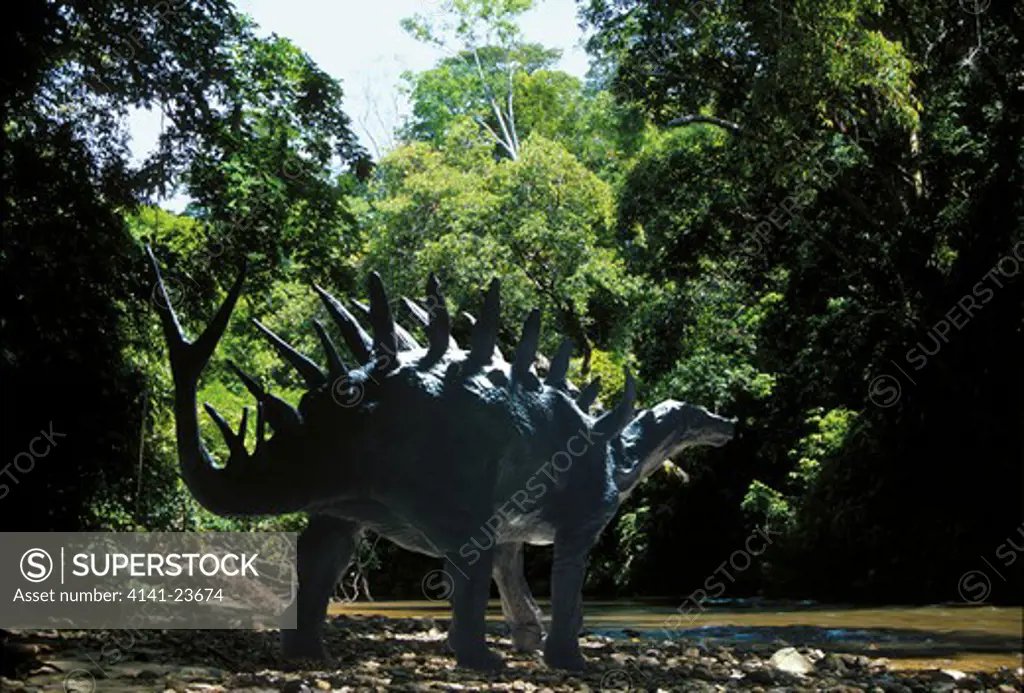 kentrosaurus a stegosaurian herbivorous dinosaur from the late jurassic period - ambling by a forest stream in what is today tanzania.
