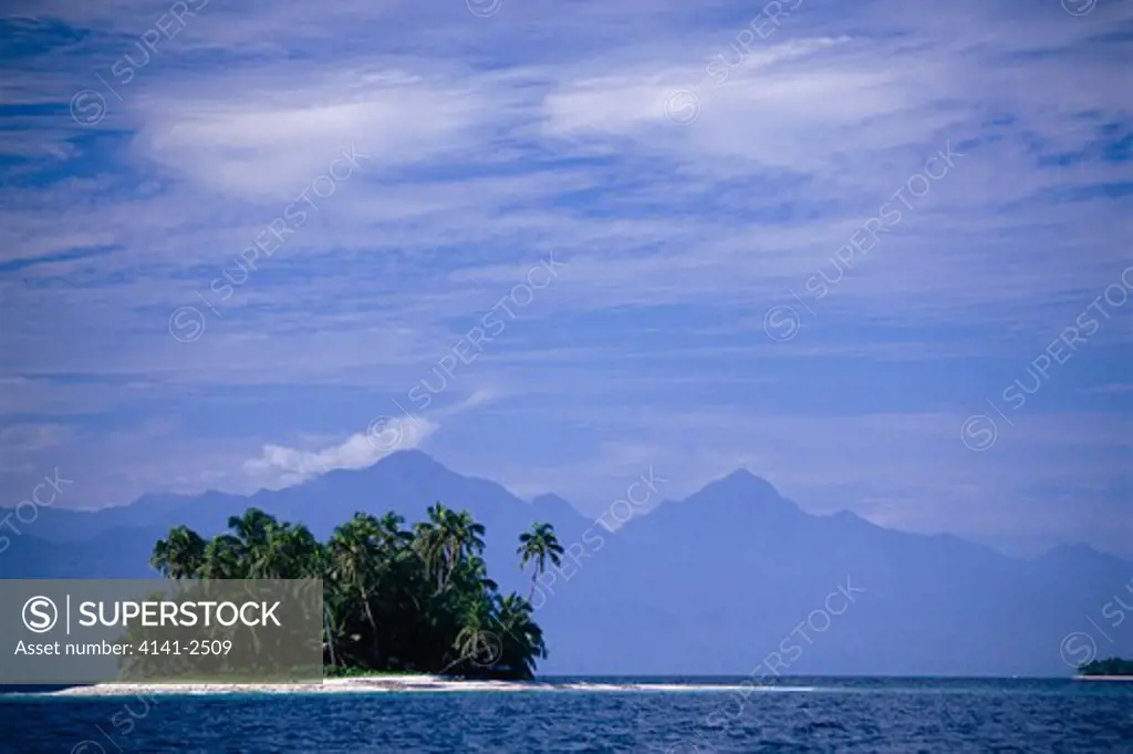 small tropical island (unnamed) mainland mountains in distance bay islands, honduras, caribbean