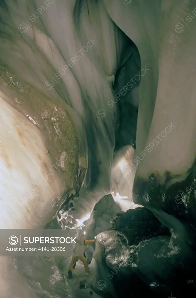 man exploring ice cave ice grotto, larsbreen, longyearbyen, svalbard, norway