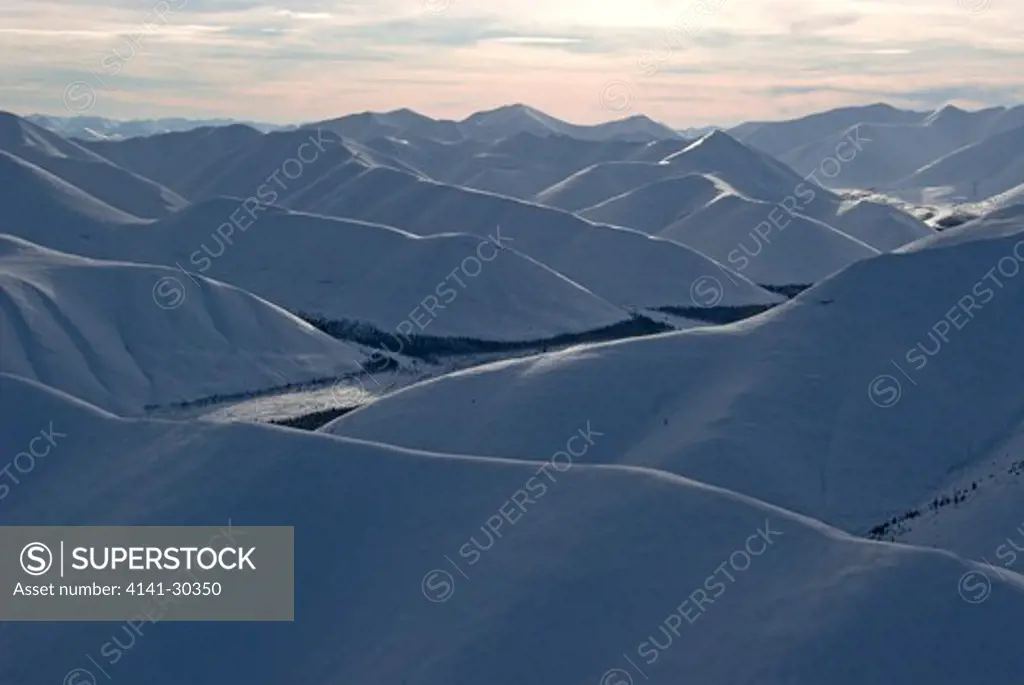 aerial of snow covered northern ogilvie mountains in yukon territory, canada.