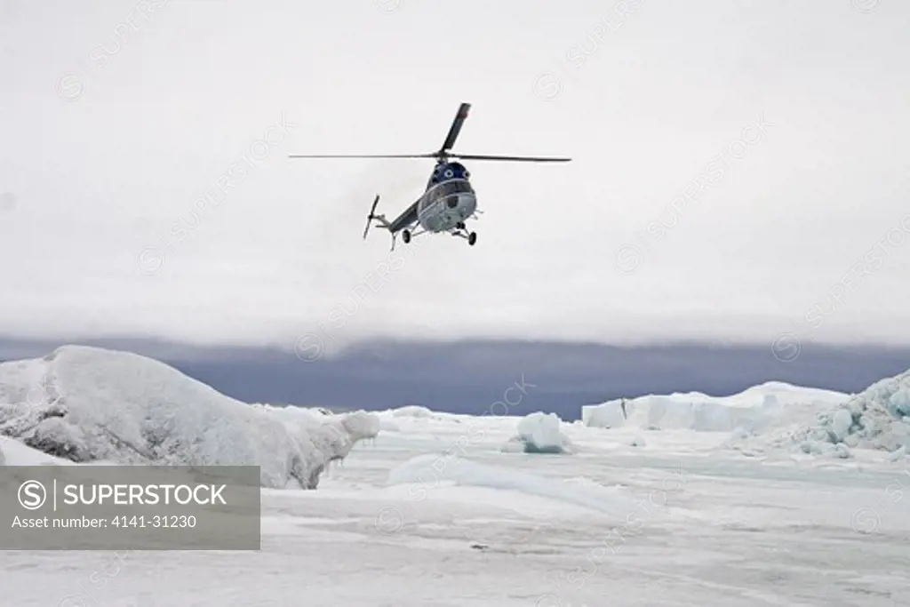 helicopter taking eco-tourists to emperor penguin colony in snow hill island antarctica
