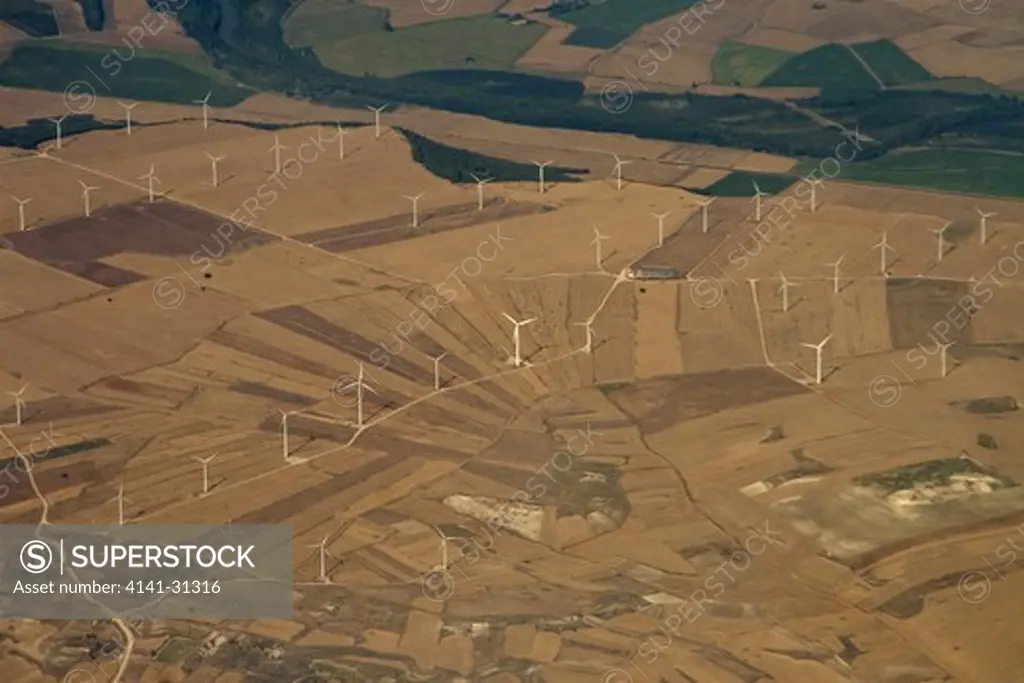 wind turbines in spanish farmland with remnant forest spain.