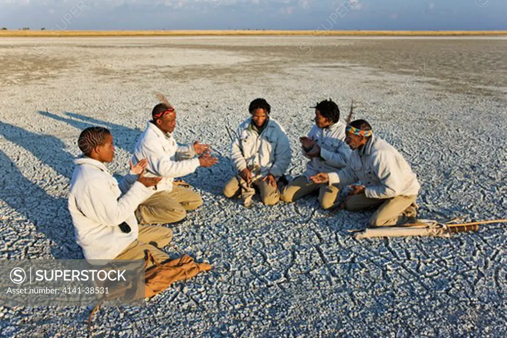 bushmen guides sitting in a half circle on the dried up makgadikgadi pans playing a traditional game. botswana date: 18.12.2008 ref: zb538_126466_0021 compulsory credit: nhpa/photoshot