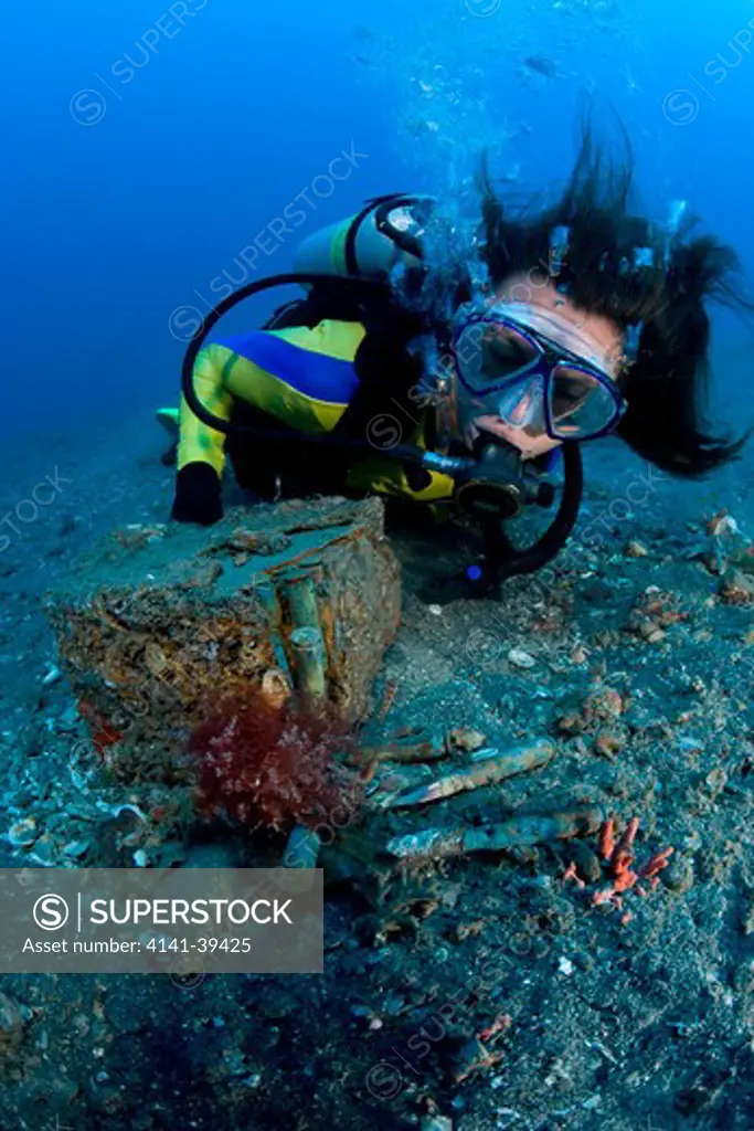 scuba diver looking a bullets box on the sand close to a japanese wreck of ii world war, lombok island, indonesia, pacific ocean date: 22.07.08 ref: zb777_117103_0021 compulsory credit: oceans-image/photoshot 