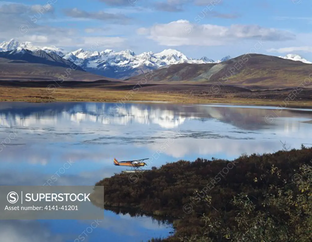 float plane on lake, denali highway, alaska mountain range in background, alaska