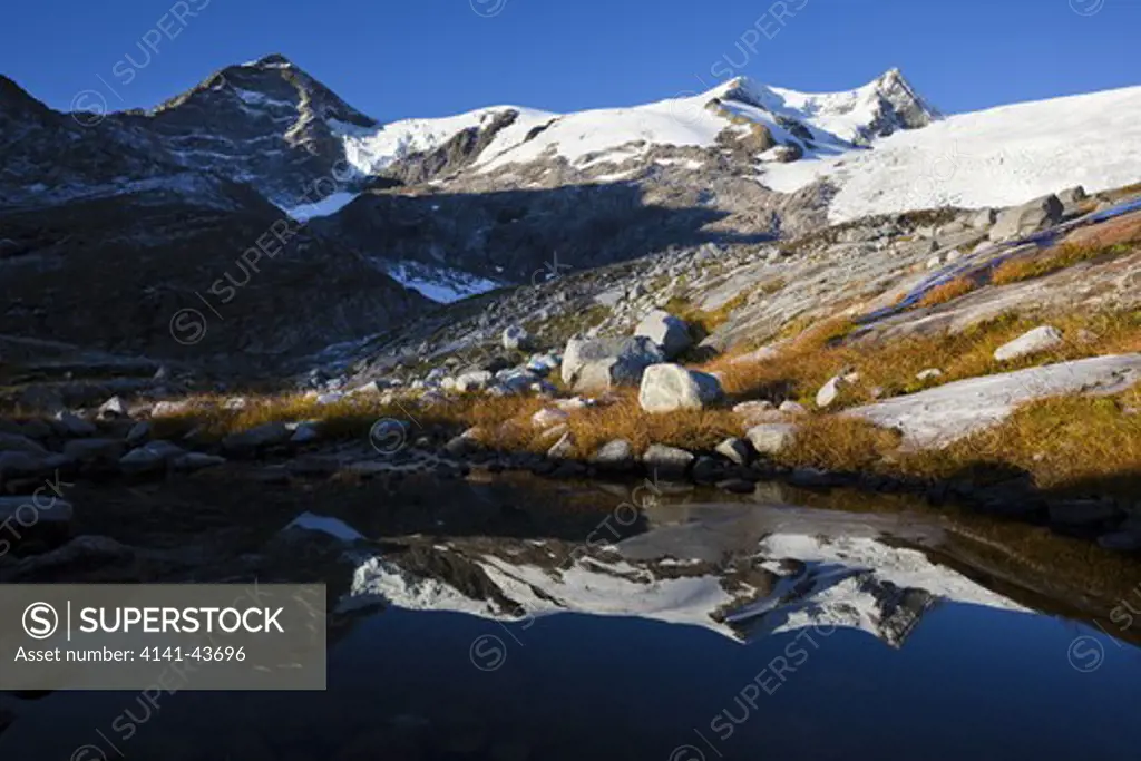 mts. kristallwand, hoher zaun, schwarze wand reflecting in pond shortly after sunrise europe, central europe, austria, east tyrol, october 2009
