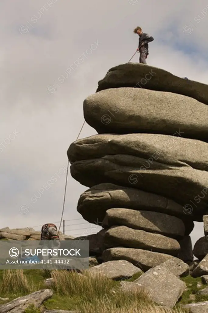 outdoor sport rock climbing, climber on top of rock stack cheesewring, minions, bodmin moor, cornwall 2009
