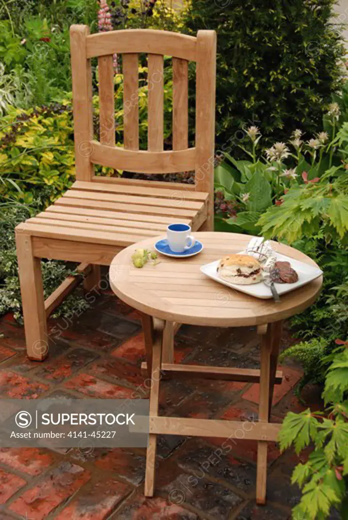 a wooden table and chair in a garden at the 2008 chelsea rhs show, london, uk. date: 10.10.2008 ref: zb898_121950_0017 compulsory credit: photos horticultural/photoshot 