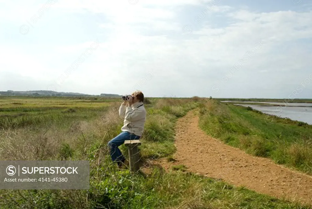 coastal path with woman watching wildfowl on marshland (burnham overy staithe, north norfolk coast) date: 19.11.2008 ref: zb899_124743_0001 compulsory credit: nhpa/photoshot 