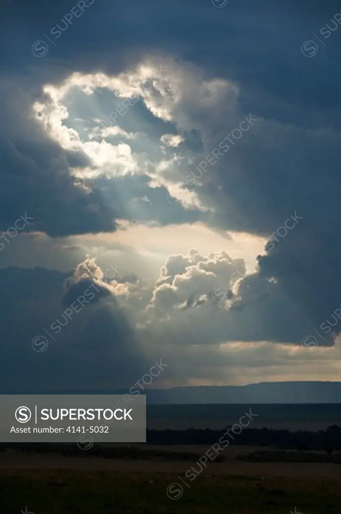 storm clouds and crepuscular rays, over masia mara, kenya