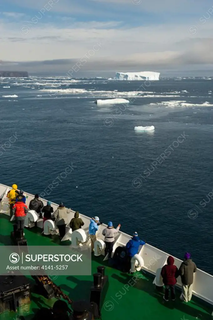 ecotourism: tourists line ships railing in antarctica