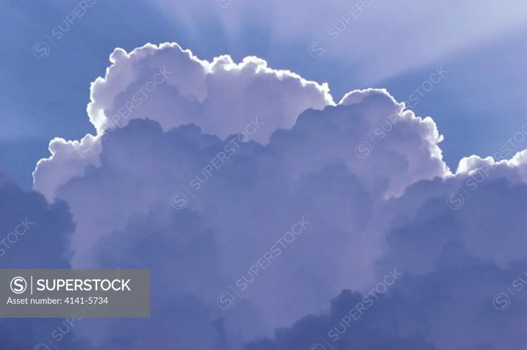 shower cumulus cloud with rays emanating from sun behind cloud