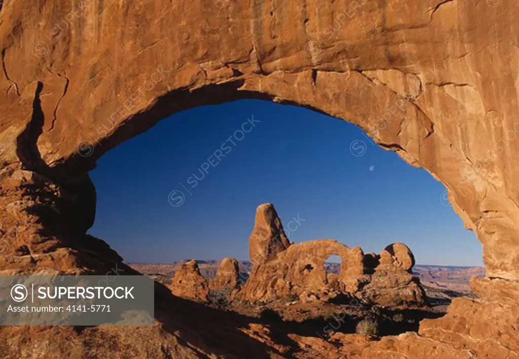 turret arch and moon seen through north window arch arches national park, utah, usa 
